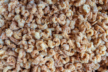 Pile of deep fried or bake pork snack, pork rind, pork scratching or pork crackling on the tray in a market