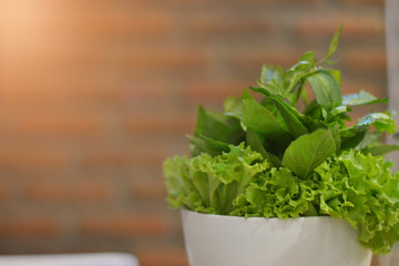 Green vegetables, set behind a brick wall