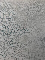 Grunge wall texture background, while the paint wall with green underneath is cracking off.