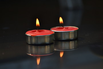 Red candle on a black background.