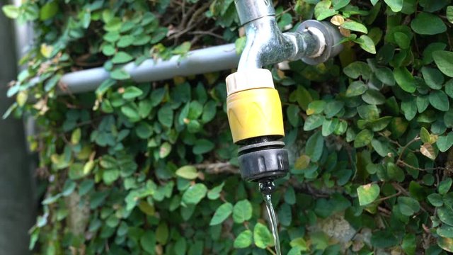 Exterior tap water dripping. Save water or hot summer concept.