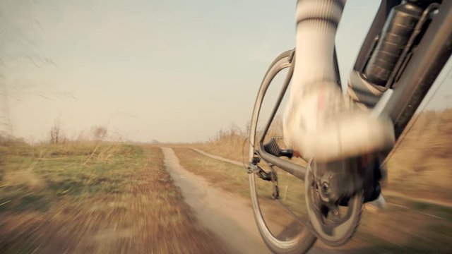 Cycling Athlete At Sunset Fall On Trail.Cyclist Twists Pedals And Riding On Gravel Bike.Gear System Bicycle And Bike Wheel Rotation.Close-Up Cyclist Pedaling On Gravel Road At Autumn. Sport Concept	