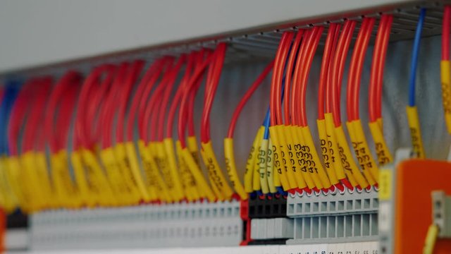 Electrical control panel with multiple switches, wires, short circuit protection devices. Color cable terminal socket and electrical control device, close up.