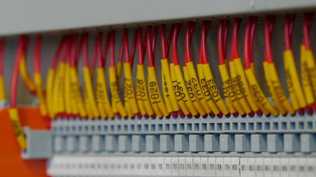 Electrical control panel with multiple switches, wires, short circuit protection devices. Color cable terminal socket and electrical control device, close up.