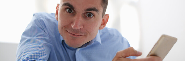 Obraz premium A businessman holds a new smartphone in his hand