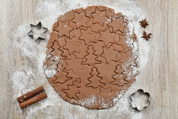 A rolled up spiced dough cut into cookie sheets with cookie cutters. Christmas, winter, new year....