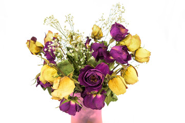 A bouquet of wilted, dry roses in a vase