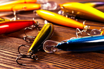 Fishing tackle background. Fishing tackles and wobbler on wooden board. Fishing hooks, lures and...