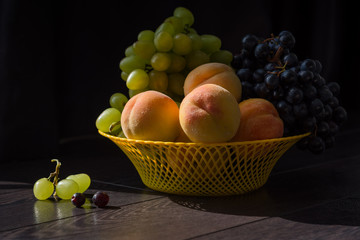 Grapes and peaches in a vase on the table