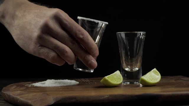 the bartender prepares tequila and dabs a stick in the salt, next to the lime