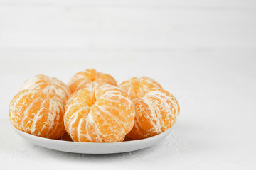 sweet and ripe peeled mandarins (tangerines) on white background isolated