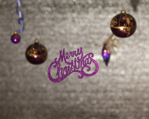 Inscription Merry Christmas on shiny background. Near Christmas toys