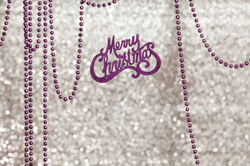 Inscription Merry Christmas on shiny background. Near garland