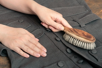 Woman cleans clothes with a cleaning brush close up.