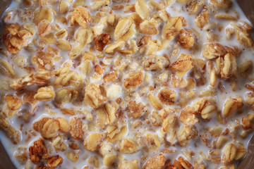 Baked granola with milk, close-up. Muesli with yogurt. Healthy breakfast.
