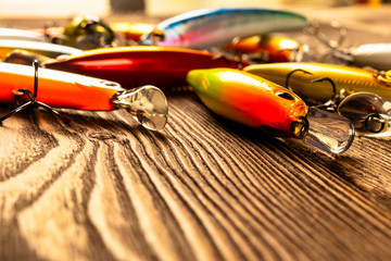 Fishing tackle background. Fishing tackles and wobbler on wooden board. Fishing hooks, lures and...