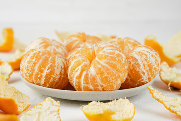 Obraz na płótnie Canvas sweet and ripe peeled mandarins (tangerines) on white background isolated