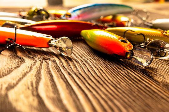 Fishing tackle background. Fishing tackles and wobbler on wooden board. Fishing hooks, lures and baits. Fishing gear on a dark table