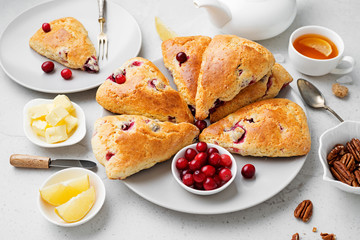 Scones with fresh cranberry and pecan nuts on gray stone background. 