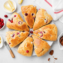 Scones with fresh cranberry and pecan nuts on gray stone background. Top view