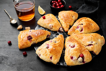 Scones with fresh cranberry  on black wooden background. 