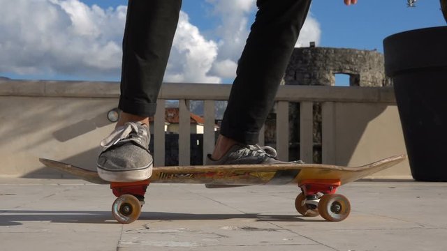 Close up of skater skateboarder man doing 360 kickflip heelflip flip trick in slow motion jump