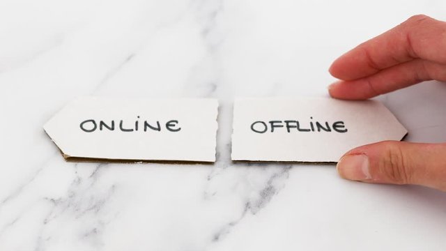 social media lifestyle and stress of an hyperconnected world conceptual video, hand placing Offline sign next to Online one pointing in opposite directions