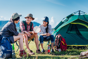 Happy group young friends in camping tent party having playing music fun together