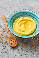Delicious  organic  mustard sauce in bowl with wooden spoon.