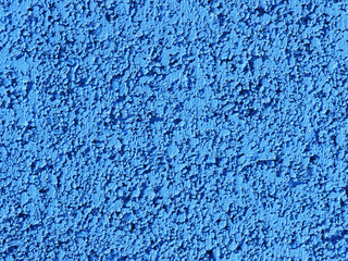 Fototapeta na wymiar Blue background facade plaster. Monolithic plaster decorative backdrop. Single layer scraped cement plaster wallpaper. Concrete exterior building structure backdrop. Silica sand cement wall plaster