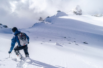 Climbers walking on a glacier using rope and ice axe. Alpinist in high alpine mountain landscape, walking in snow. Adventure outdoor activity.