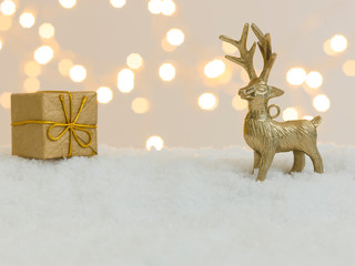 many different christmas items on white snow with many small, shining lights in the background