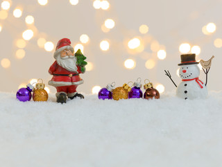 many different christmas items on white snow with many small, shining lights in the background