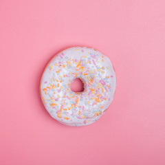 Fototapeta na wymiar Delicious donut coated with a white frosting and sprinkles of different colors