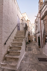 Fototapeta na wymiar View of a typical alley with cobblestones and stairs in Ceglie Messapica (Italy)