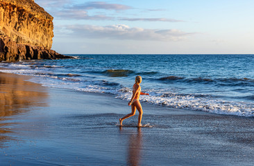 Family holiday. Children swim in the sea. Beach in Taurito, Gran Canaria. Ocean and rocks.