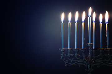 Fototapeta premium Religion image of jewish holiday Hanukkah background with menorah (traditional candelabra) and candles