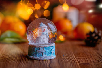 Christmas Snow Globe With Christmas Decoration Over Wooden Background