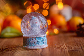 Christmas Snow Globe With Christmas Decoration Over Wooden Background