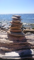pebble beach, flat stones stacked on top of each other in the form of a pyramid, selective focus