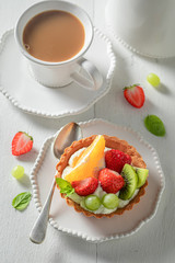 Fresh mini tart with fresh fruits, mint and whipped cream
