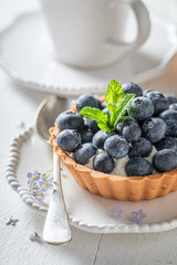 Freshly baked mini tart with fresh blueberries and mint
