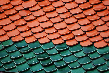 Abstract scene of Brown and green  earthenware tiles or calls tiles consists of fish scales on the roof of temple bangkok thailand