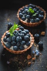 Delicious mini tart with blueberries and whipped cream