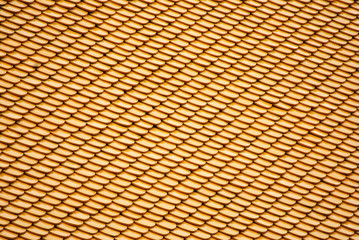 Abstract scene of Yellow earthenware tiles or calls tiles consists of fish scales on the roof of temple bangkok thailand - yellow backgroud surface concept