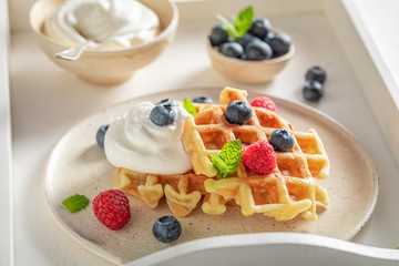 Homemade waffles with berries and whipped cream