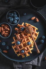 Homemade waffles with blueberries, honey and almont