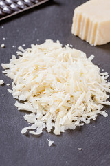 geriebener Parmesankäse auf einer Schiefertafel angerichtet