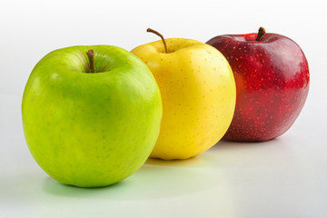 Apples green, yellow and red on a white background.