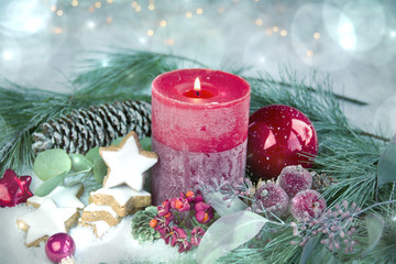 Erster Advent - Rote Adventskerze mit Bokeh Lichtern im Schnee  